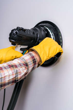 Electric putty grinder in the hands of a workerの写真素材