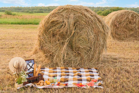 Picnic in nature in a field near a round haystackの写真素材