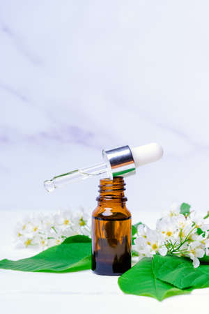 aplle essential oil with a branch with blooming flowers, white marble backgroundの写真素材