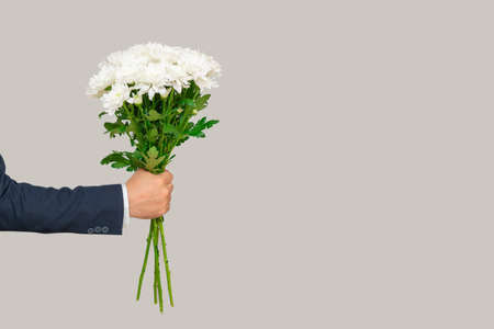 bouquet of white chrysanthemums in a man's hand. copy spaceの写真素材