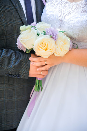 A man and a woman holding a wedding bouquet together, close-up.の写真素材