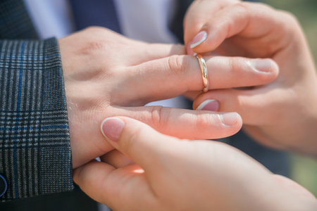A woman puts an engagement ring on a man. close-up.の写真素材