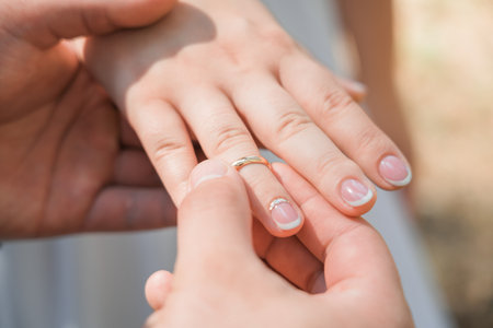 A man puts a wedding ring on a woman's finger, Close-up.の写真素材