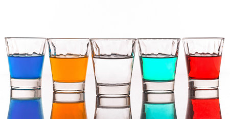 Five little glasses reflected on white backgroundの写真素材