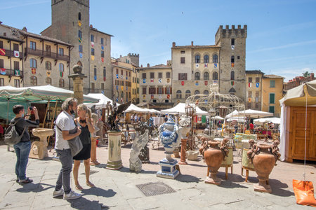 Arezzo's Piazza Grande in Tuscany during the traditional antiques fair with tourists strolling on a sunny summer day on 3 July 2021のeditorial素材