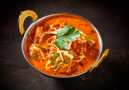 Close-up of Chicken Tikka Masala, an Indian dish with boneless chicken marinated in yogurt, spices, ginger, garlic, chili, onions, and peppers, garnished with cream and cilantroの写真素材