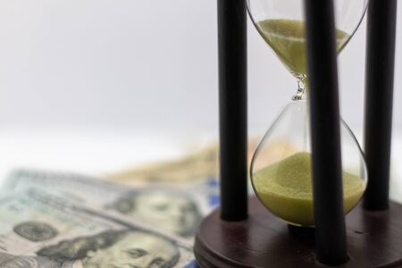 Time is money concept. Business concept. Time running. Hourglass and money. Selective focus. text...