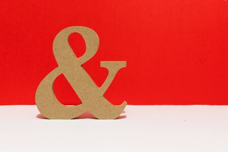 Wooden letter, and sign, red background. Metaphorical for couples love and being together for ever.の写真素材
