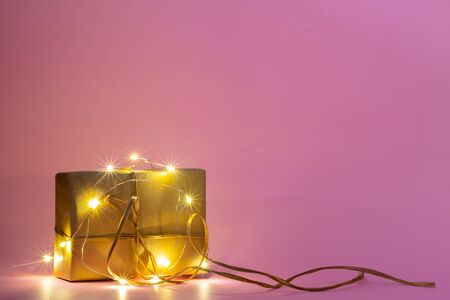 Square present wrapped with kraft paper and bow, in a rustic and simple manner, with shinning lights...