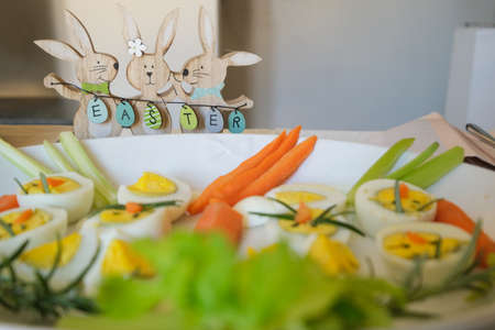 Easter Bunny Ornament with appetizer of boiled eggs on the table, Italy
