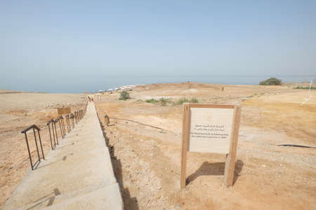 Signboard at the Dead Sea. Stairs leading to the ocean. A landlocked salt lake between Israel and Jordan in southwestern Asia. Ten times saltier than the ocean. Seascape against the blue sky.のeditorial素材