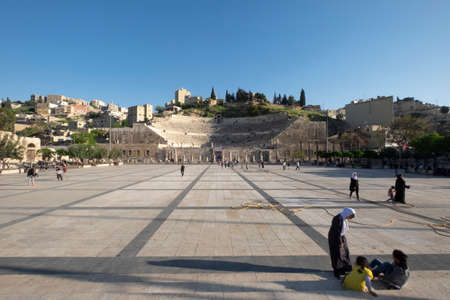 Tourists in front of the historic Roman amphitheater in Amman Jordan. One of the most important tourist attractions. It is at the foot of Jabal Al-Joufah, on a hill opposite the Amman Citadel.のeditorial素材