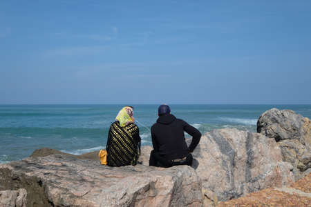 Muslim couple sitting on the rock in front of River Bou Regreg and Kasbah of Udayas fortress in Medina of Rabat, the capital of Morocco. Located on the Atlantic Ocean at the mouth of the river Bou Regreg.のeditorial素材