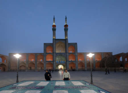 Yazd, Iran: Muslim tourists at the Amir Chakhmaq Square with old hosseinieh decorated with azure tiled patterns and topped with twin minarets. Most notable landmark.のeditorial素材