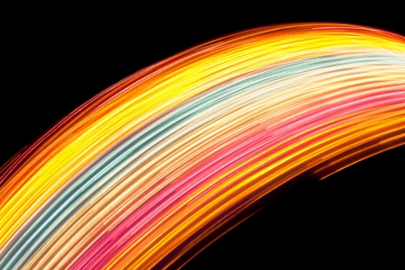 forming colored curved lights trails strip against the black night sky background