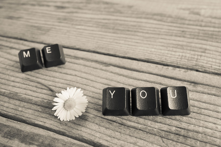 "you and me" wrote with keyboard keys on wooden background, black and white effectの写真素材