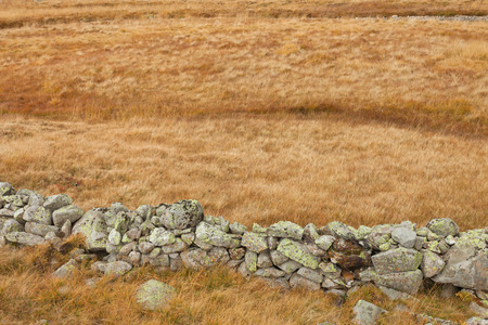 wall built up with natural stones to protect animals in the meadowの写真素材
