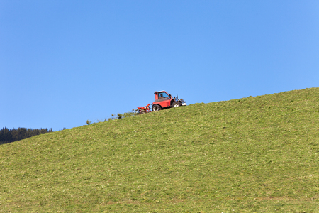 Mechanical tool used by the farmer to move the hay on the meadow, during the sunny daysの写真素材
