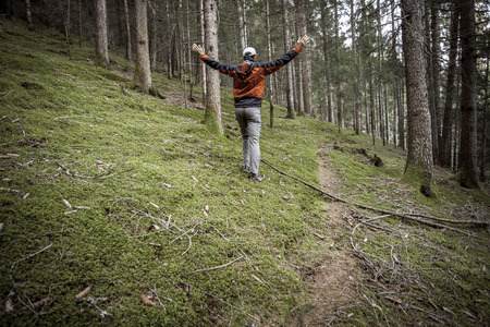 A trekker walking solo  among the forest in a cloudy day