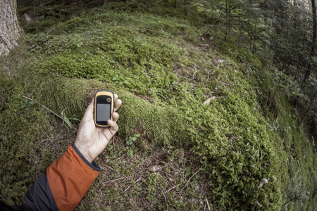 A trekker using gps among the forest in a cloudy dayの写真素材