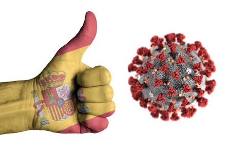 Spain flag on human male thumb up hand during covidの写真素材
