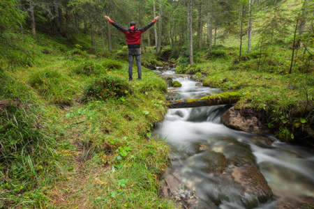 A trekker walking solo among the forest in a cloudy day