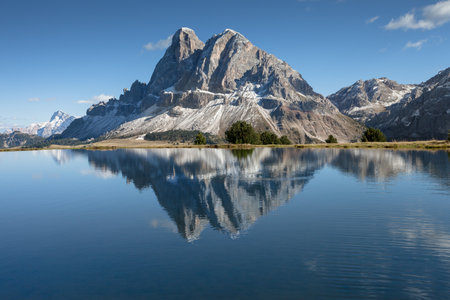 Sass de Putia reflects itself over a small alpine lake in Dolomites at eveningの写真素材