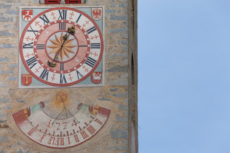NAZ-SCIAVES, ITALY - OCTOBER 13, 2019: The recently restored clock and sundial painted outside the bell tower of the church of the town.のeditorial素材