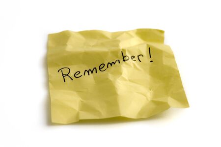Yellow crumpled sticky note with remember word, isolated on white background. Picture taken in...