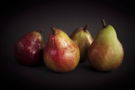Ripe pears isolated on dark background. Still-life picture taken in studio with light-box.の写真素材
