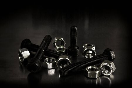 Metallic bolts and nuts. Low-key concept picture taken in studio.の写真素材