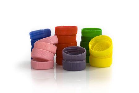 Stacks of plastic bottle caps on white background. Still-life picture taken in studio with soft-box.