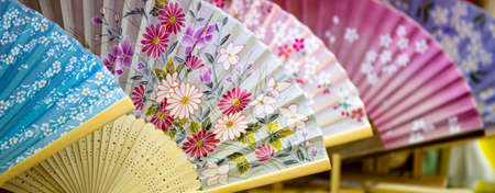 Japanese paper fans. Several folding fans with floral patterns displayed in a souvenir shop in Tokyo, Japan.の写真素材