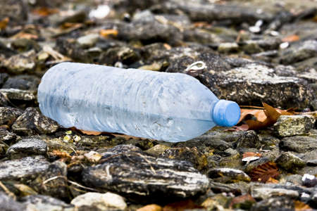Plastic bottle abandoned on a pebble beach. Concept image concerning pollution and environmental protection.の写真素材