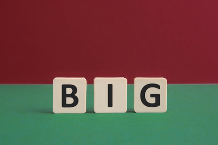 Word BIG written with leisure game tiles. Conceptual image representing a textual message communicated using letters from a board game.の写真素材