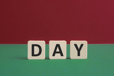 Word DAY written with leisure game tiles. Conceptual image representing a textual message communicated using letters from a board game.の写真素材