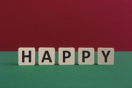 Word HAPPY written with leisure game tiles. Conceptual image representing a textual message communicated using letters from a board game.の写真素材