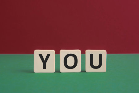 Word YOU written with leisure game tiles. Conceptual image representing a textual message communicated using letters from a board game.の写真素材