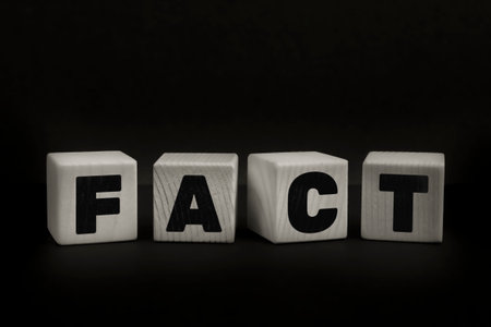 Word FACT written with wooden cubes. Studio shot of some arranged wooden blocks with a textual message about disinformation.の写真素材