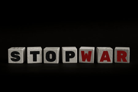 Message STOP WAR written with wooden blocks on dark background. Studio shot of a textual message taken using wooden cubes aligned on a low-key set.の写真素材