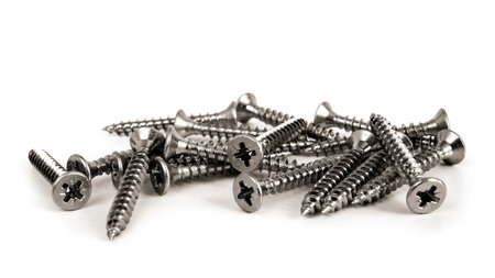 Scattered screws isolated on white. Still-life picture of small hardware parts taken on studio with white background and softboxの写真素材