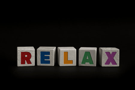 Word RELAX written with wooden cubes. Studio shot of some arranged wooden blocks with a textual message.の写真素材