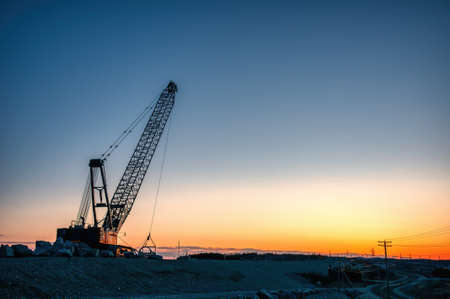 Cable excavator at sunset on construction site