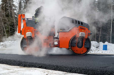 Roller compactor and asphalting in winter on a road