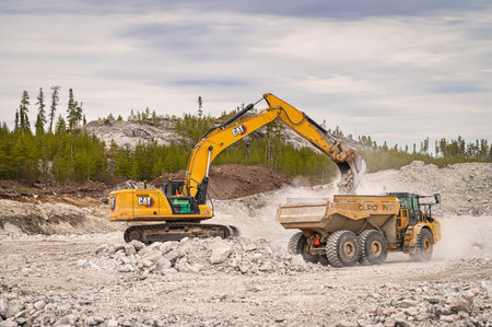 Eleonore mine, north of Quebec, Canada, 2023-05-18: An excavator loading a dump truck with stone at a mining site in northern Canadaのeditorial素材