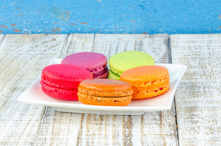 Colorful macarons on vintage pastel background. Macaron or Macaroon sweet meringue-based confection.の写真素材