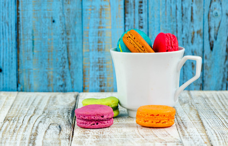 Colorful macarons on vintage pastel background. Macaron or Macaroon sweet meringue-based confection.の写真素材