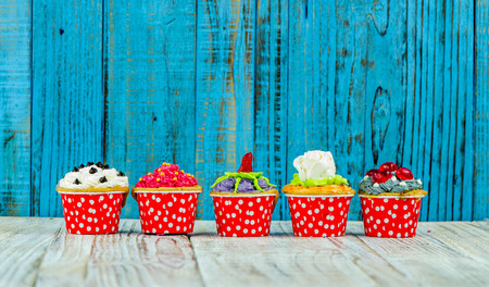 Colorful cupcakes on a wooden backgroundの写真素材