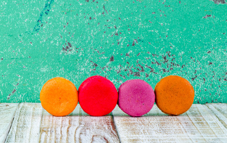 Colorful macarons on vintage pastel background. Macaron or Macaroon sweet meringue-based confection.の写真素材