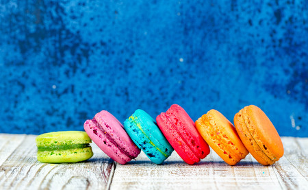 Colorful macarons on vintage pastel background. Macaron or Macaroon sweet meringue-based confection.の写真素材